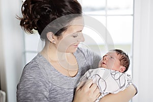 Happy mother holding adorable child baby on the living room