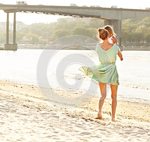 Happy mother holding her bay girl at beach