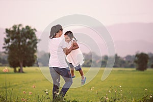 Happy mother holding her kid and spinning around with fun