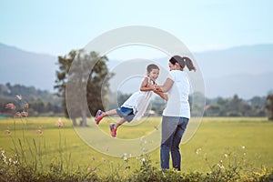 Happy mother holding her kid and spinning around with fun