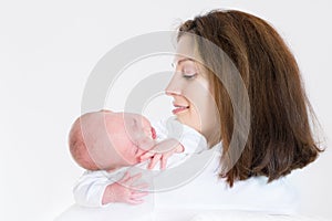 Happy mother holding her sleeping newborn baby