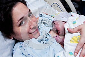 Happy mother holding newborn baby after birth