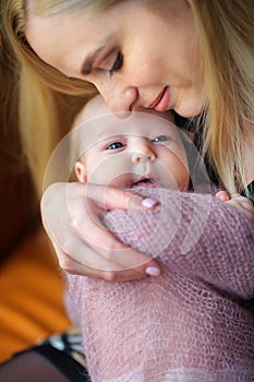 Happy mother holds on hands of the newborn baby