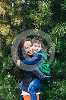 A happy mother holds her son in her arms. A mother`s love and tenderness