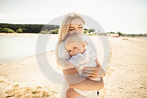 Happy mother huges baby. Mother holds child in her arms, baby hugging mom, close-up