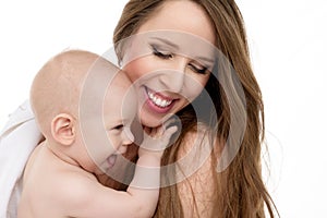 Happy mother hugging her adorable baby son. Mother and newborn child portrait isolated on white background.