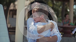 Happy Mother Hugging Her Child on the Coast. Cute Kid Kisses His Mom and Gently Hugs. Concept Mom With a Child Outdoors