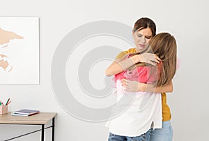 Happy mother hugging her teenager daughter