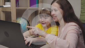 happy mother hugs child. happy family life. fun learning home with mom together computer. children teacher explains