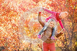 Happy mother and kid having fun together outdoor in autumn