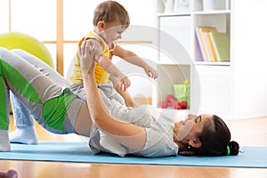 Happy mother and kid making healthy fitness exercises