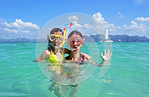 Happy mother and kid snorkeling in tropical sea