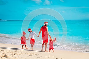 Happy mother with kids on beach Christmas vacation