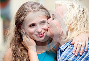 Happy mother kissing her daughter