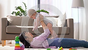 Happy mother with little baby boy playing at home