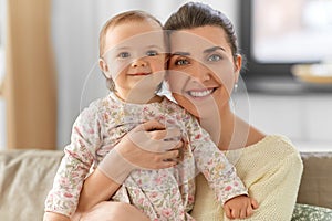 Happy mother with little baby daughter at home