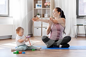 Happy mother with little baby exercising at home