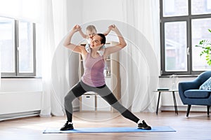 Happy mother with little baby exercising at home