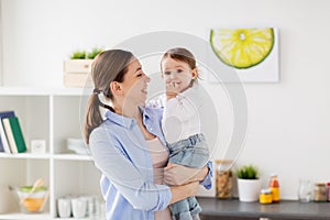 Happy mother and little baby girl at home kitchen