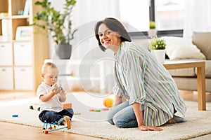 Happy mother with little baby son playing at home