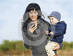 Happy mother with little boy on cellphone