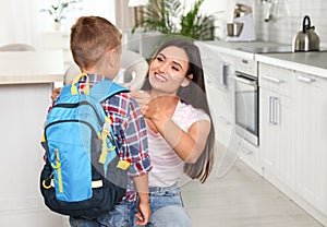 Happy mother and little child with backpack ready for school