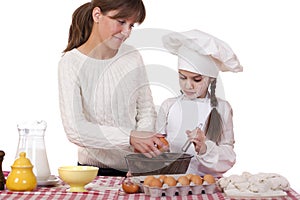 Happy mother with little daughter joyful cooking