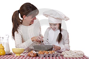 Happy mother with little daughter joyful cooking
