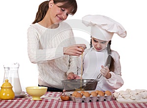 Happy mother with little daughter joyful cooking