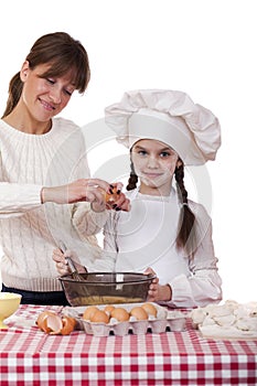 Happy mother with little daughter joyful cooking