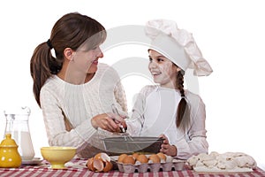 Happy mother with little daughter joyful cooking