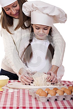 Happy mother with little daughter joyful cooking