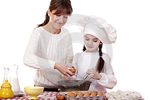 Happy mother with little daughter joyful cooking