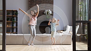 Happy mother with little daughter jumping in modern living room photo