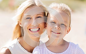 Happy mother and little daughter on summer beach