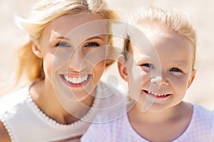 Happy mother and little daughter on summer beach