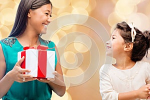 Happy mother and little girl with gift box