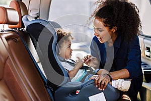 Happy mother looking at her son in a baby seat