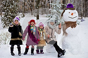 Happy mother of many children sculpt a big real snowman