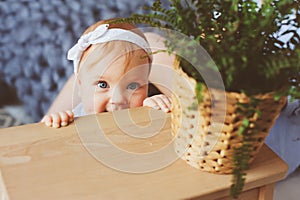 Happy mother and 9 month old baby in matching pajamas playing in bedroom in the morning