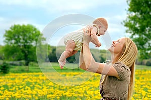 Happy Mother and Newborn Baby Girl Playing Outside