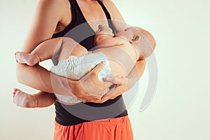 Happy mother with newborn baby infant on hands standing and breasfeeding lacting lactation health and care bonding time