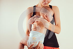 Happy mother with newborn baby infant on hands standing and breasfeeding lacting lactation health and care bonding time