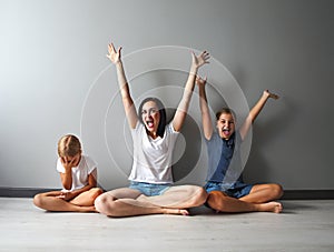 Happy mother and one of her daughters excited sitting in living