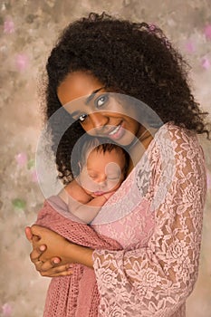 Happy mother in pink lace dress with baby