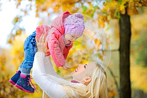 Happy mother playing with her baby in a beautiful park