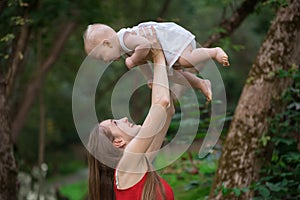 Happy mother playing with her baby outdoors. Togetherness concept with kid