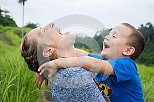 Happy mother playing with her son in the park