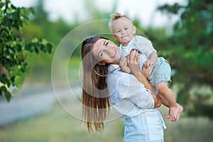 Happy mother playing with her son in the park