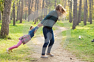 Happy mother playing with his daughter in the park  in summer day